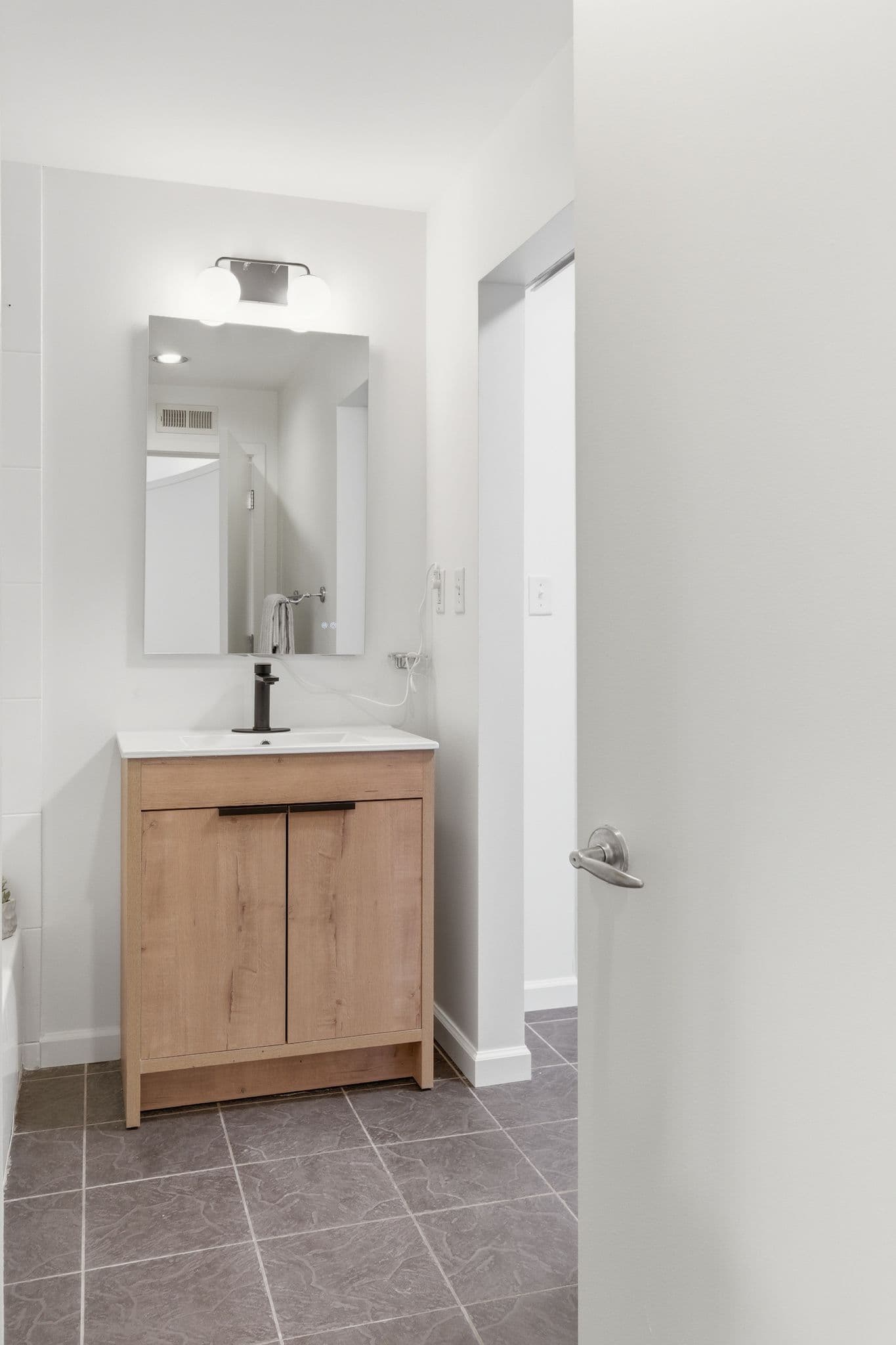 Bathroom with light wood vanity and freshly painted walls in a Nashville loft