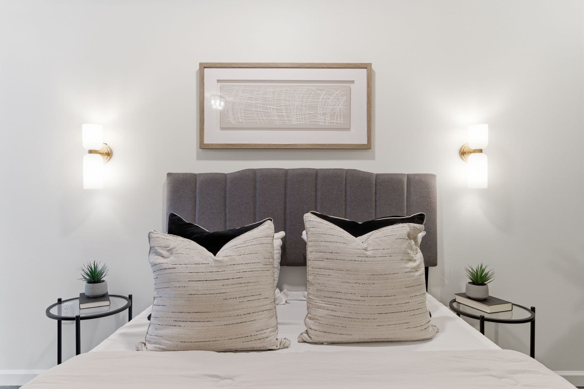 Bedroom headboard centered between sconces with newly painted walls