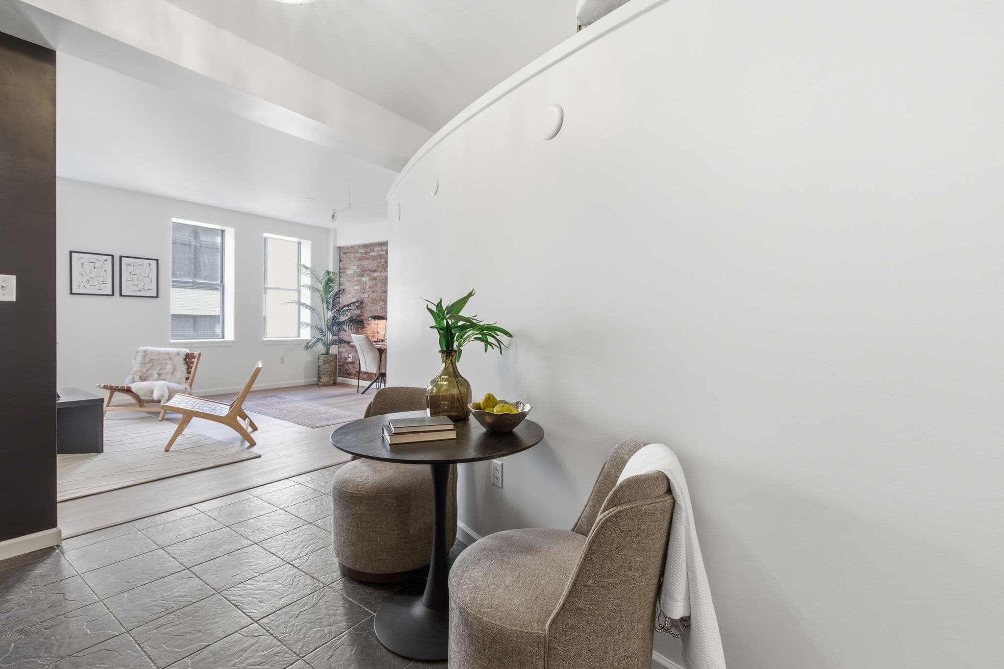 Curved painted hallway with view into a brick-walled living room