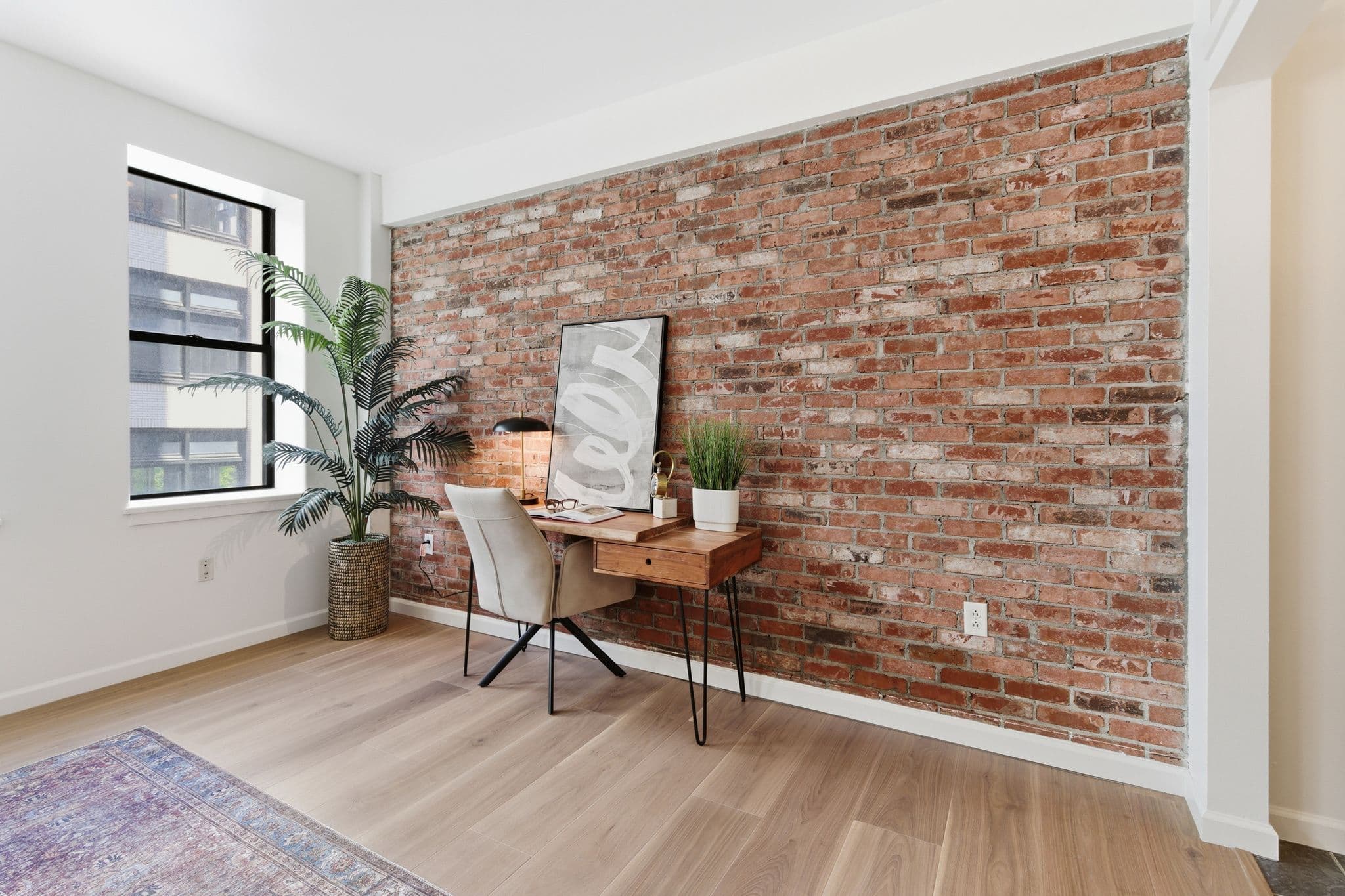 Desk against exposed brick wall in a Nashville loft painted by Walsh Painting