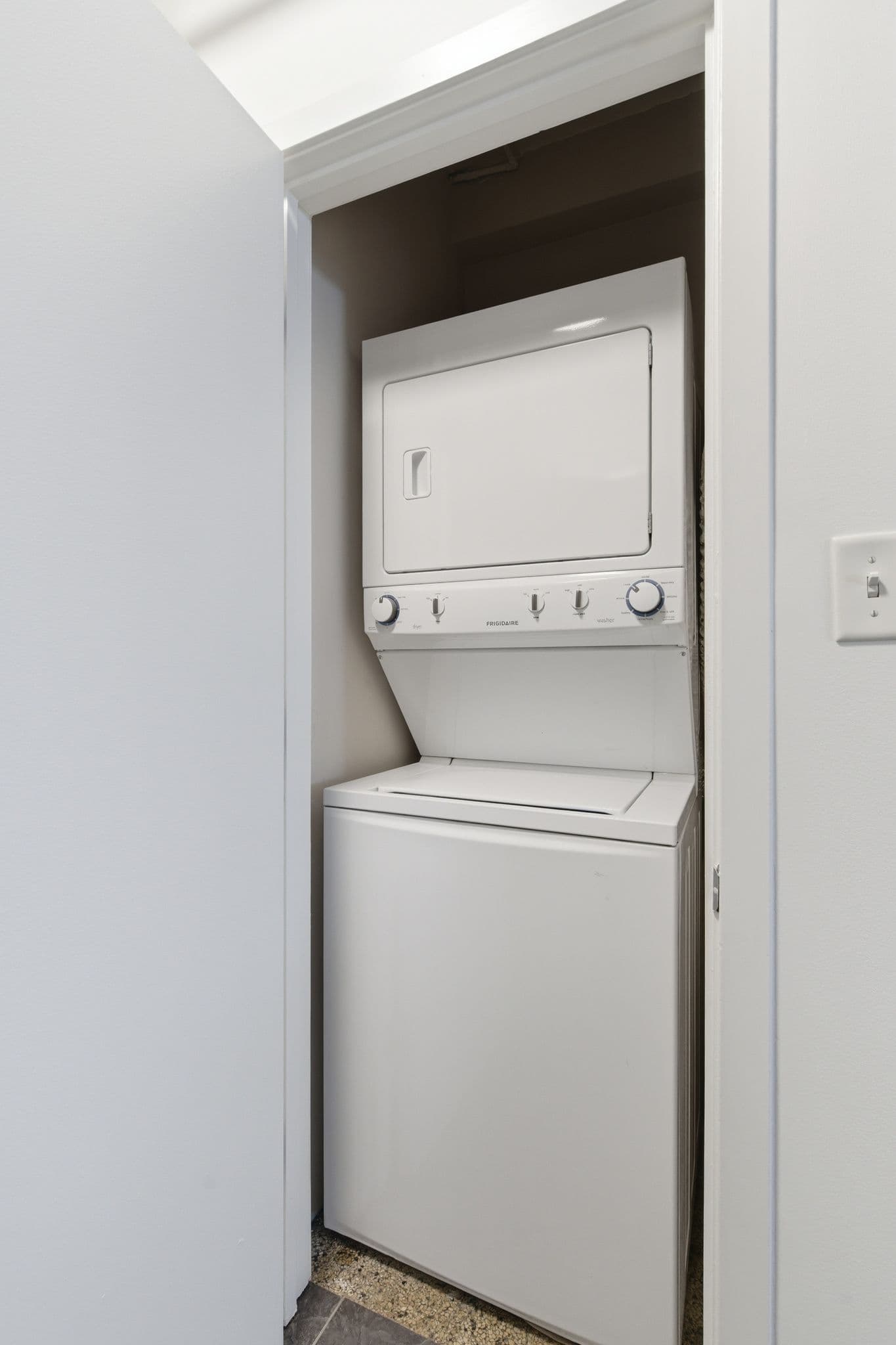 Laundry closet with stacked washer-dryer and painted walls