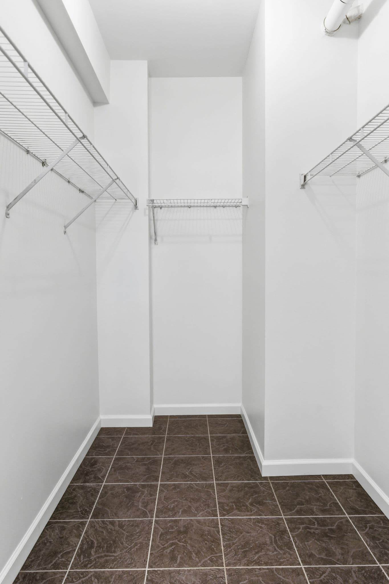 Empty walk-in closet with freshly painted white walls and ceiling